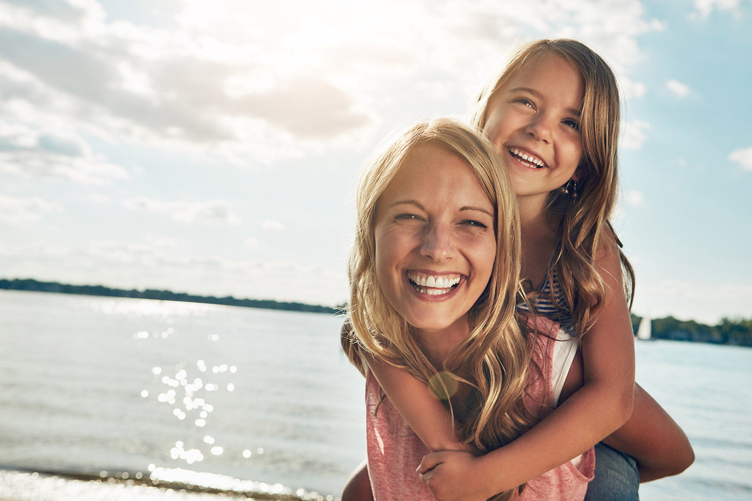 Smiling woman and child on a beach
